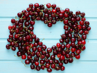 Cerezas formando un corazón sobre fondo azul