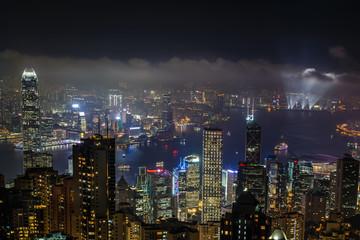 Aerial night view from Victoria peak to Kowloon bay and illuminated skyscrapers of Hong Kong island, China republic