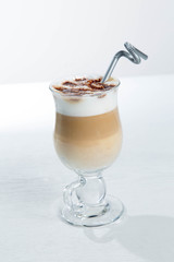 Glass of cold latte coffee topic cocolate cream on isolated white background with desserts