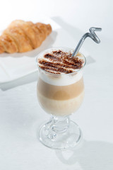 Glass of cold latte coffee topic cocolate cream on isolated white background with desserts