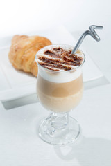 Glass of cold latte coffee topic cocolate cream on isolated white background with desserts