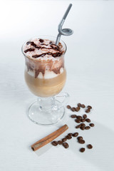 Glass of cold latte coffee topic cocolate cream on isolated white background with desserts