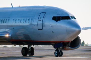 Close-up the front of the passenger plane taxiing on the airport apron
