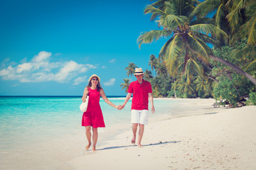 Obraz na płótnie Canvas happy loving couple walk on beach
