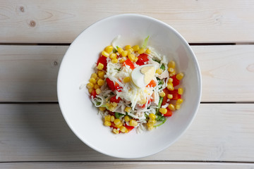 Salad with corn, egg, pepper, cheese. Top view.