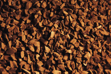 Instant coffee granules scattered brown closeup.