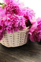 Pink peonies in a white basket on the table