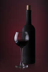 Pouring red wine into the glass against wooden background