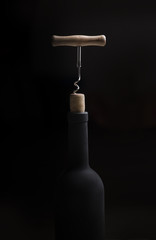 Pouring red wine into the glass against wooden background