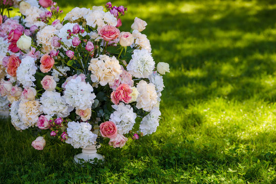 Vintage vase with roses and Hydrangea, eucalyptus bouquet outdoor on the grass