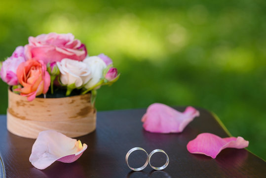 Wedding rings lay on the flower composition for the ceremony