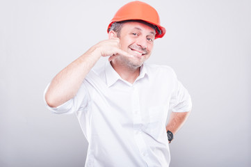 Portrait of architect wearing  hardhat showing calling gesture