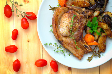 Grilled pork steak and vegetables on the grill. Horizontal, rustic style. Wooden background. Close-up. Top view