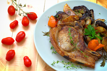 Grilled pork steak and vegetables on the grill. Horizontal, rustic style. Wooden background. Close-up. Top view