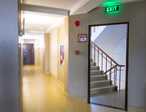 Building Emergency Exit with Exit Sign and Fire Extinguisher. stairwell fire escape in a modern building.
