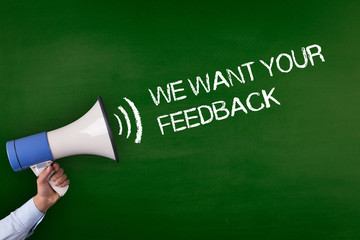 Hand Holding Megaphone with WE WANT YOUR FEEDBACK Announcement