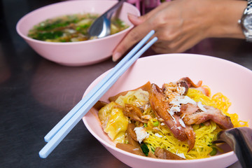 Wonton noodle with BBQ pork and crab meat on stainless table