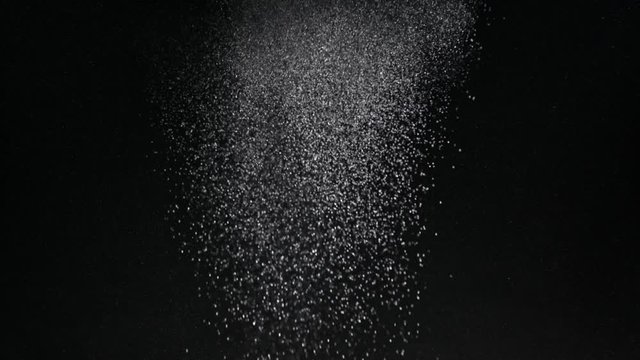 Burst of particles coming in from top of frame studio shot 4K