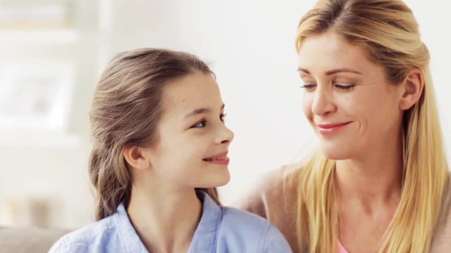 mother and girl turning to each other at home
