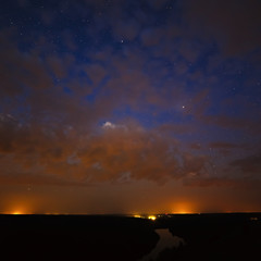 Clouds at night on the background of bright stars in the sky.
