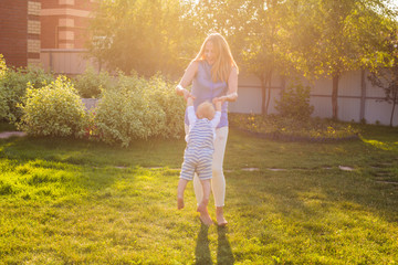 Playful woman in the garden playing with her baby son