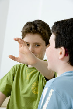 Models Do not use for HIV Young boy using the French sign language to discuss with his hearing-impaired brother The French sign language uses signs to designate words but also dactylology (each letter of the alphabet is represented by a defined position of the fingers then enabling to spell a word) and the lip reading The young boy designates the letter \c\ (see image nﾰ0833202 ans series of images from nﾰ0572308 to 0574108 to see the other letters of the alphabet)