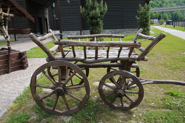 Fototapeta na wymiar Wooden horse cart on green field in garden