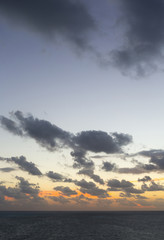 Sunrise behind the horizon on the sea shore.