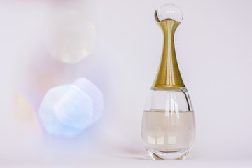 Glamourios woman perfume on a white background with bokeh.