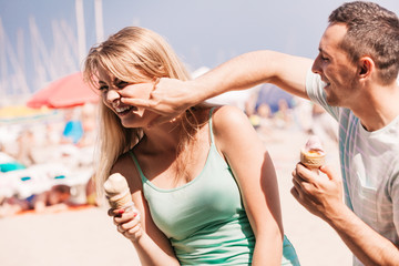 Man and woman eating ice cream on beach