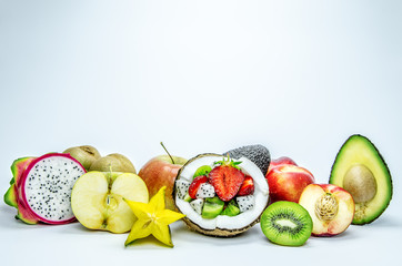 Kiwi, apple, avocado, сarambola fruit, peach and dragon fruit in a cut. In the middle half of the coconut with pieces of strawberry and kiwi inside.