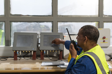 Worker at site office talking at radio device