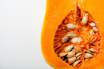 Butternut squash halved on white background with copy space. Closeup. Organic food concept.