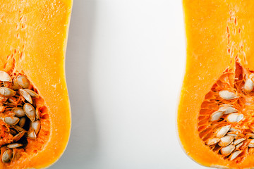 Butternut squash halved on white background with copy space. Closeup. Organic food concept.