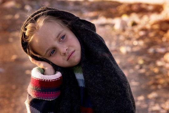 Sad little girl in a landfill