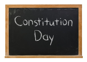 Constitution Day written in white chalk on a black chalkboard isolated on white