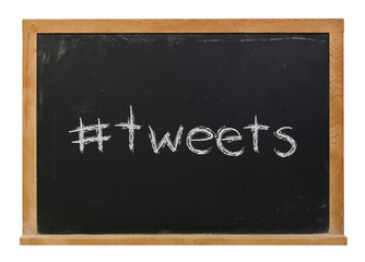 Hashtag tweets written in white chalk on a black chalkboard isolated on white