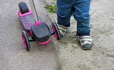 Obraz premium Dziecko jadące na hulajnodze.