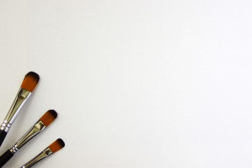 Three black paintbrushes on white background