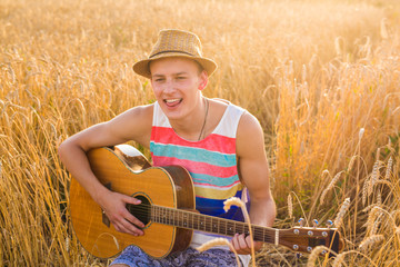A man is playing guitar in grass field at relax day with sun light