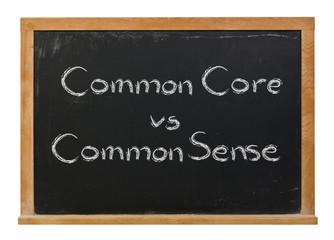 Common Core vs Common Sense written in white chalk on a black chalkboard isolated on white