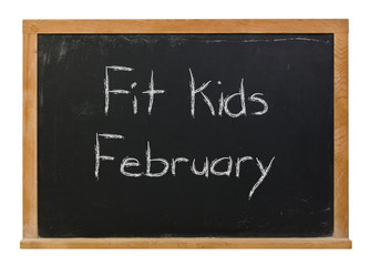 Obraz premium Fit Kids February written in white chalk on a black chalkboard isolated on white