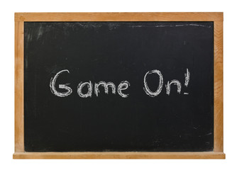 Fototapeta premium Game on written in white chalk on a black chalkboard isolated on white