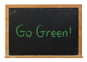 Go Green written in green chalk on a black chalkboard isolated on white