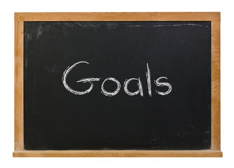 Goals written in white chalk on a black chalkboard isolated on white