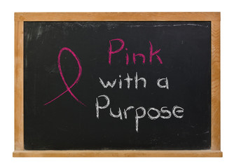 Pink ribbon with a purpose written in white chalk on a black chalkboard isolated on white
