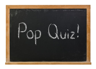 Pop quiz written in white chalk on a black chalkboard isolated on white
