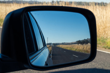 View of a road in the rear view mirror