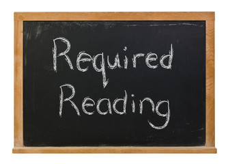 Obraz premium Required reading written in white chalk on a black chalkboard isolated on white 