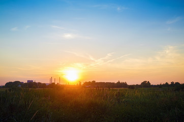 Scenic colorful sunset. Sun sets over the horizon in countryside.